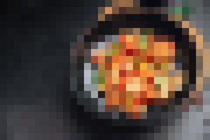 Top-down view of a round skillet or pan containing a colorful, saucy dish with orange, red, and yellow tones; the image is highly pixelated and details are unclear.