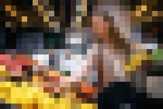 Blurred photo of a person standing behind a counter in a warmly lit bar or restaurant setting.