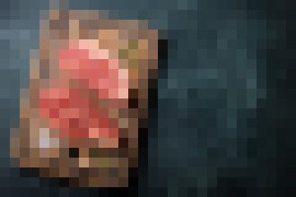 Pixelated red, heart-like object on the left with a dark background on the right.