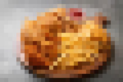 Round, golden-brown baked pastry or dish on a dark surface, seen from above.