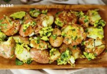 სანამ კიდევ არის ახალი კარტოფილი. Ჩაიწერეთ ეს რეცეპტი და აუცილებლად მოამზადეთ Roasted potato halves on a wooden tray, tossed with chopped parsley and a yellow-green herb sauce.