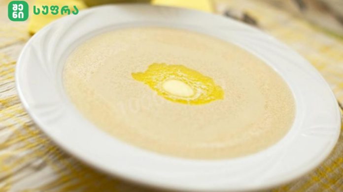 Creamy soup served in a white bowl with a small pat of butter in the center.