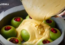 Შარლოტა ფარშირებული ვაშლით Green apples hollowed and arranged in a round cake pan, batter being poured over them for baking.