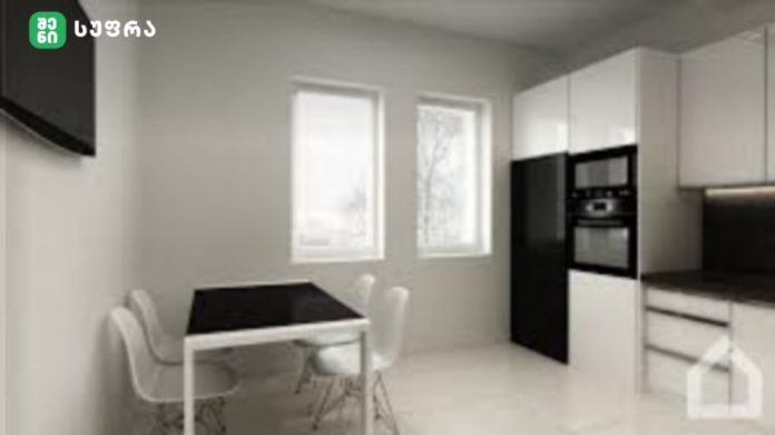 Modern white kitchen with black dining table and white chairs, built-in oven, and bright windows on the right side.