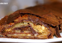 უგემრიელესი შოკოლადის შტრუდელი მსხლით. Cross-section of a flaky, chocolate-covered pastry filled with chopped nuts.