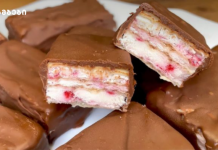 ვაფლის ბატონები Chocolate-coated wafer bars with white cream filling and pink bits, some pieces broken open to show layers on a plate (logo in corner).