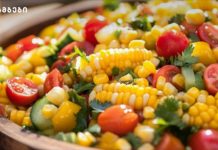 მექსიკური დიპი Colorful corn salad with cherry tomatoes, cucumber, bell peppers and fresh herbs in a wooden bowl
