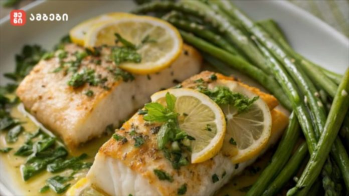 Two lemon-garnished pan-seared fish fillets in butter sauce with asparagus on a plate