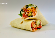 ვრაპი რომელიც ძალიან სწრაფად მზადდება Two soft wraps filled with chicken and fresh veggies, placed on a white surface; logo in the upper-left corner.