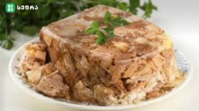 shenisupra-xaladeci-1024x575 Shredded cooked meat piled on a white plate, with a parsley garnish on top.