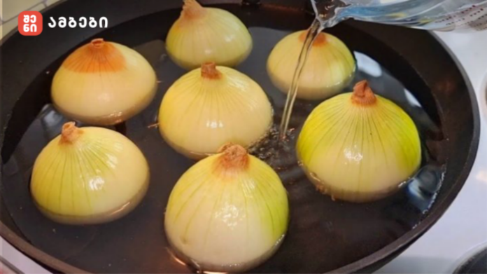 xaxvi Yellow onions boiling in a large pot of water on a stove surface. They are submerged and simmering in the liquid.