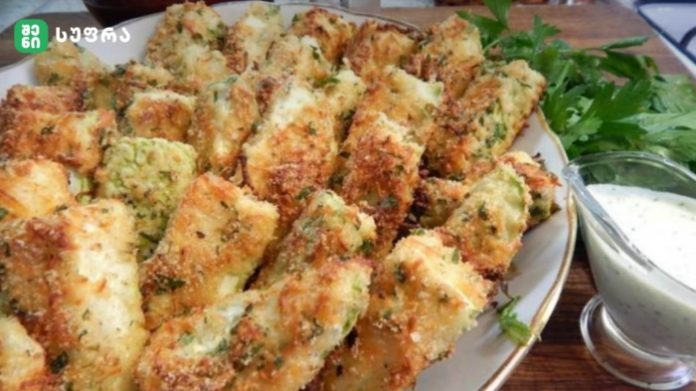 yabayi Plate of golden-brown breaded, herb-crusted fried sticks with a side of creamy dipping sauce and parsley garnish.