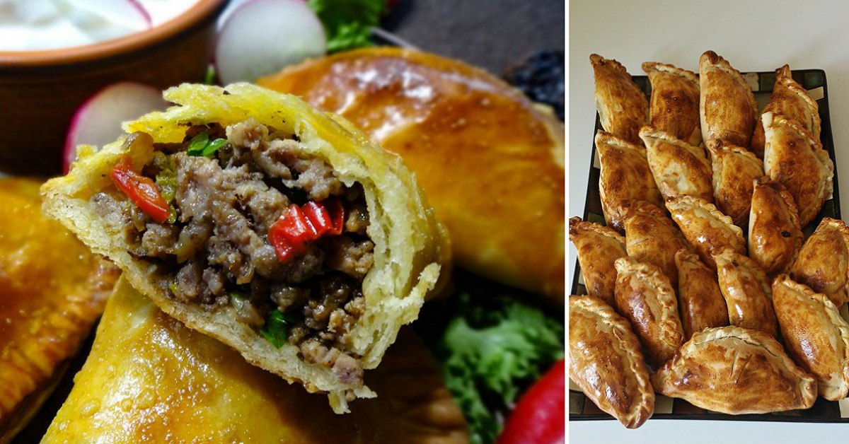 Cross-section of a beef empanada showing minced beef with red peppers and herbs inside a flaky crust.