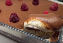 ჟოლოსა და კაკაოს დესერტი Chocolate dessert in a glass baking dish with raspberries on top; a spoon lifts a bite to reveal creamy layers inside.