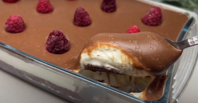 deserti Chocolate dessert in a glass baking dish with raspberries on top; a spoon lifts a bite to reveal creamy layers inside.