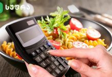 რომელია სამი ყველაზე კალორიული კერძი Person holding a handheld calculator over a bowl of pasta with cherry tomatoes and parsley in a kitchen setting