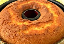 ფხვიერი კექსის რეცეპტი Golden-brown Bundt cake cooling in a dark tube pan with a central hole visible at the top edge of the pan.