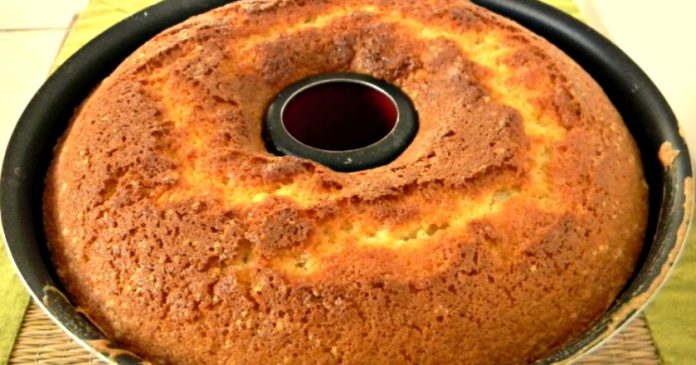 keksi Golden-brown Bundt cake cooling in a dark tube pan with a central hole visible at the top edge of the pan.