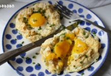 კვერცხის ღრუბლები პარმეზანით Two egg-in-a-hole portions on a blue-polka-dot plate, garnished with chives, with a knife and fork nearby.