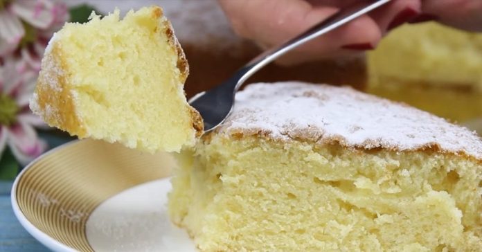 A light yellow sponge cake on a plate, a fork lifting a bite dusted with powdered sugar.