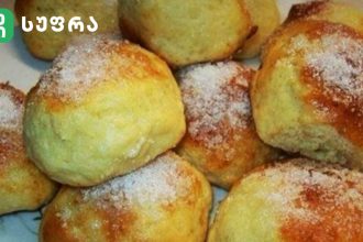 Pile of small round pastries with greenish-yellow crusts, lightly dusted with sugar.