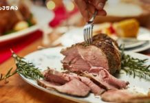 ღორის მკერდი სოიოს სოუსში – აზიურად Sliced roast beef on a plate with rosemary sprigs and a fork resting on top of the meat