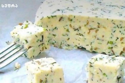 Herb butter cubes with chopped greens on a plate, a fork nearby