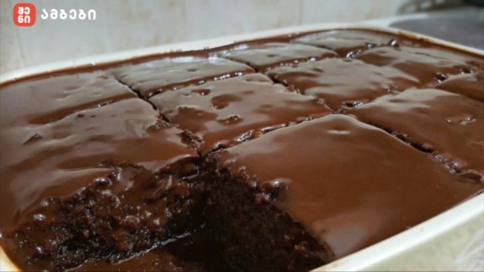 Tray of glossy chocolate brownies cut into squares, cooling in a pan with a rich dark glaze