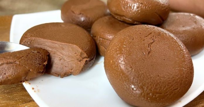 shokoladis pudingi Plate of round chocolate truffles with a creamy interior, some cut open to show the filling.