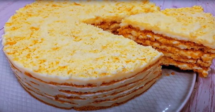 Layered yellow cake with white frosting and crumb topping, sliced to reveal multiple cream-filled layers on a plate
