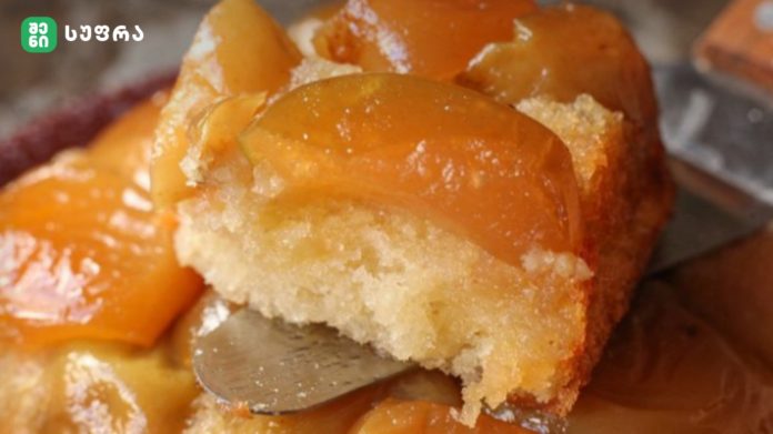 Close-up of orange-glazed doughnuts with a crumbly sugar topping on a plate.