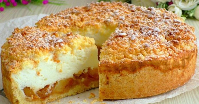 Crumb-topped cheesecake with a creamy center and fruit filling, a slice removed on a plate.