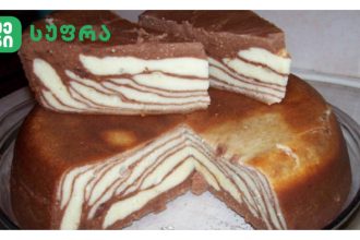 Zebra-striped chocolate and vanilla layer cake on a glass plate with a green logo in the top-left corner.